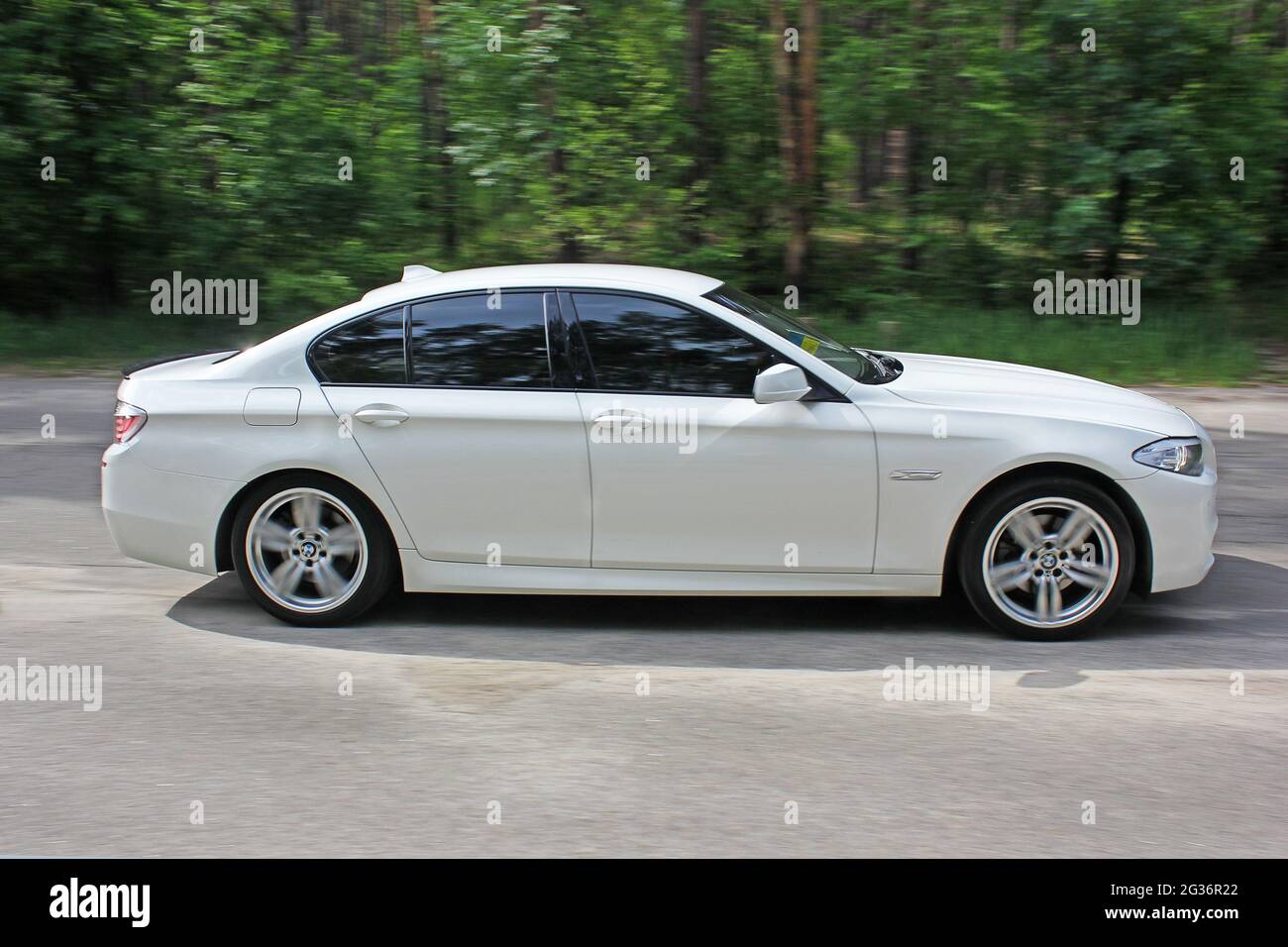 Kiev, Ukraine - May 17, 2014: White BMW 520 TDI (F10) M Sport in the forest road Stock Photo