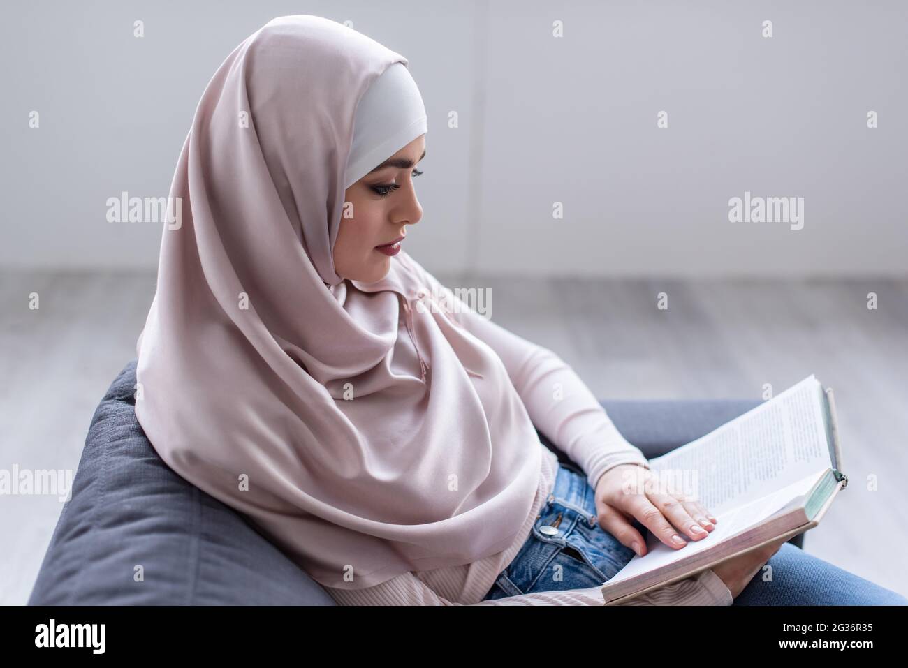 young arabian woman in hijab reading book at home Stock Photo - Alamy