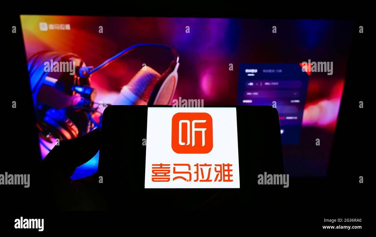 Person holding mobile phone with logo of Chinese online radio platform  Ximalaya on screen in front of business web page. Focus on phone display  Stock Photo - Alamy