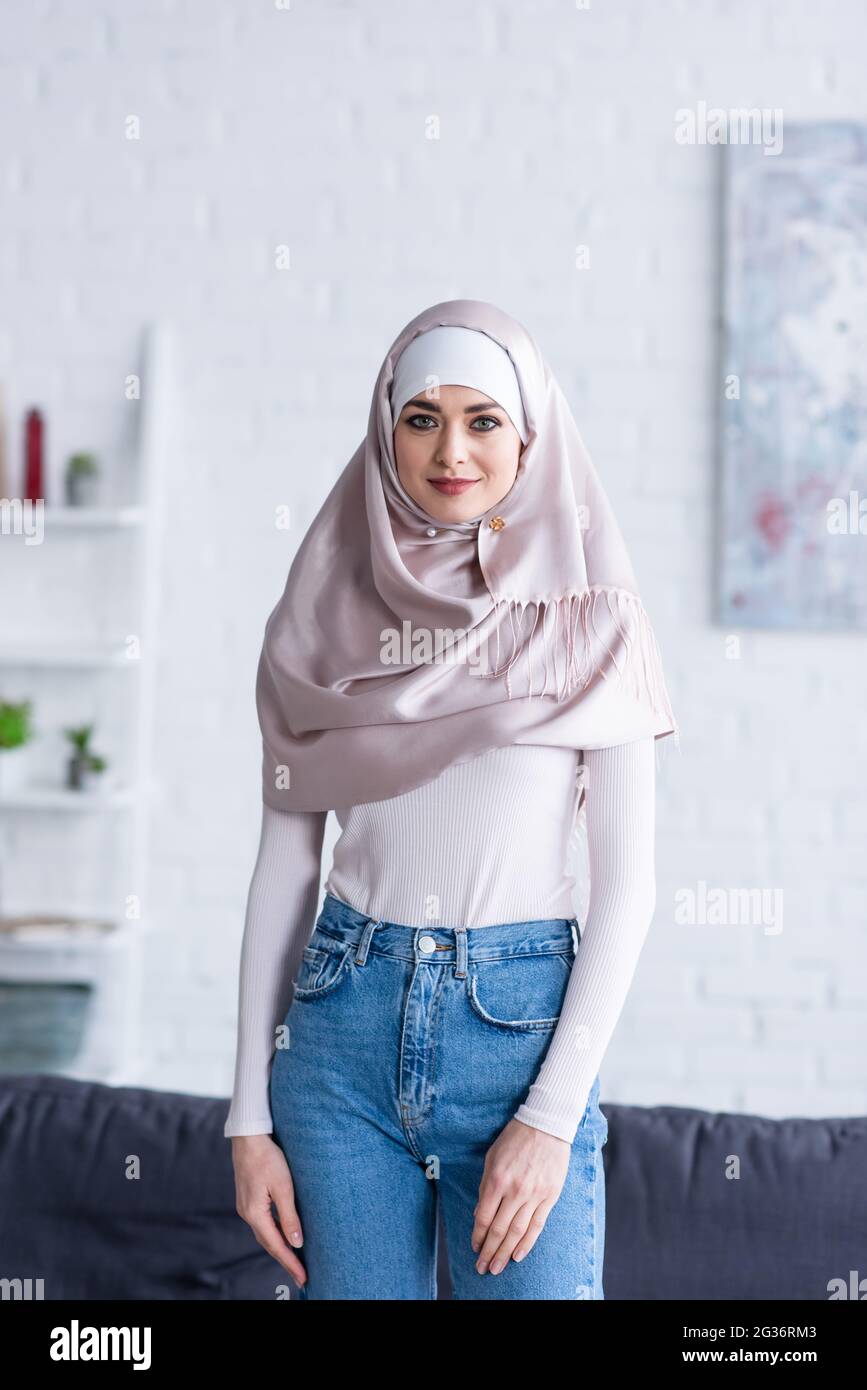 young arabian woman in hijab and jeans looking at camera at home Stock  Photo - Alamy