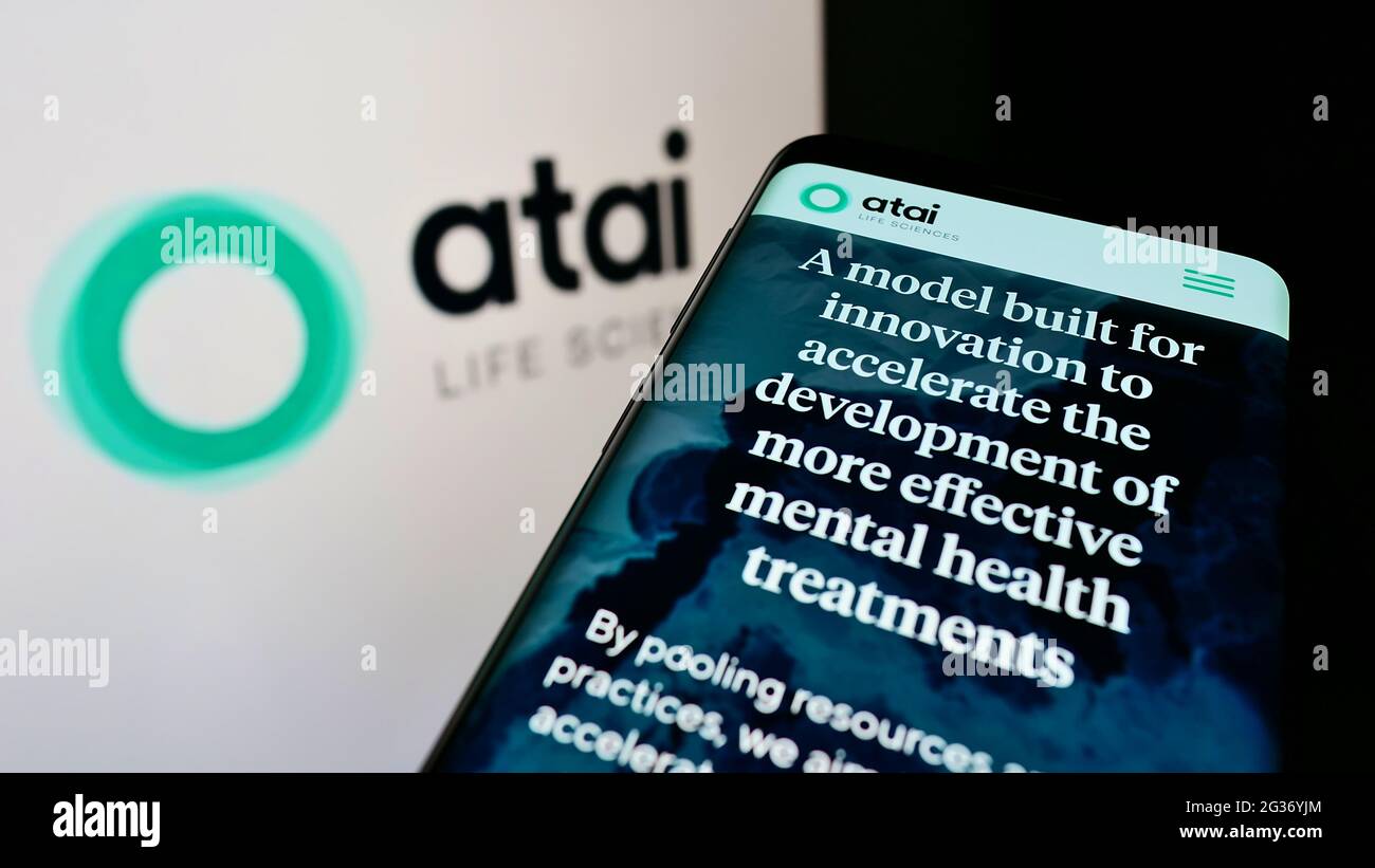 Cellphone with webpage of German biotech company ATAI Life Sciences AG on screen in front of business logo. Focus on top-left of phone display. Stock Photo