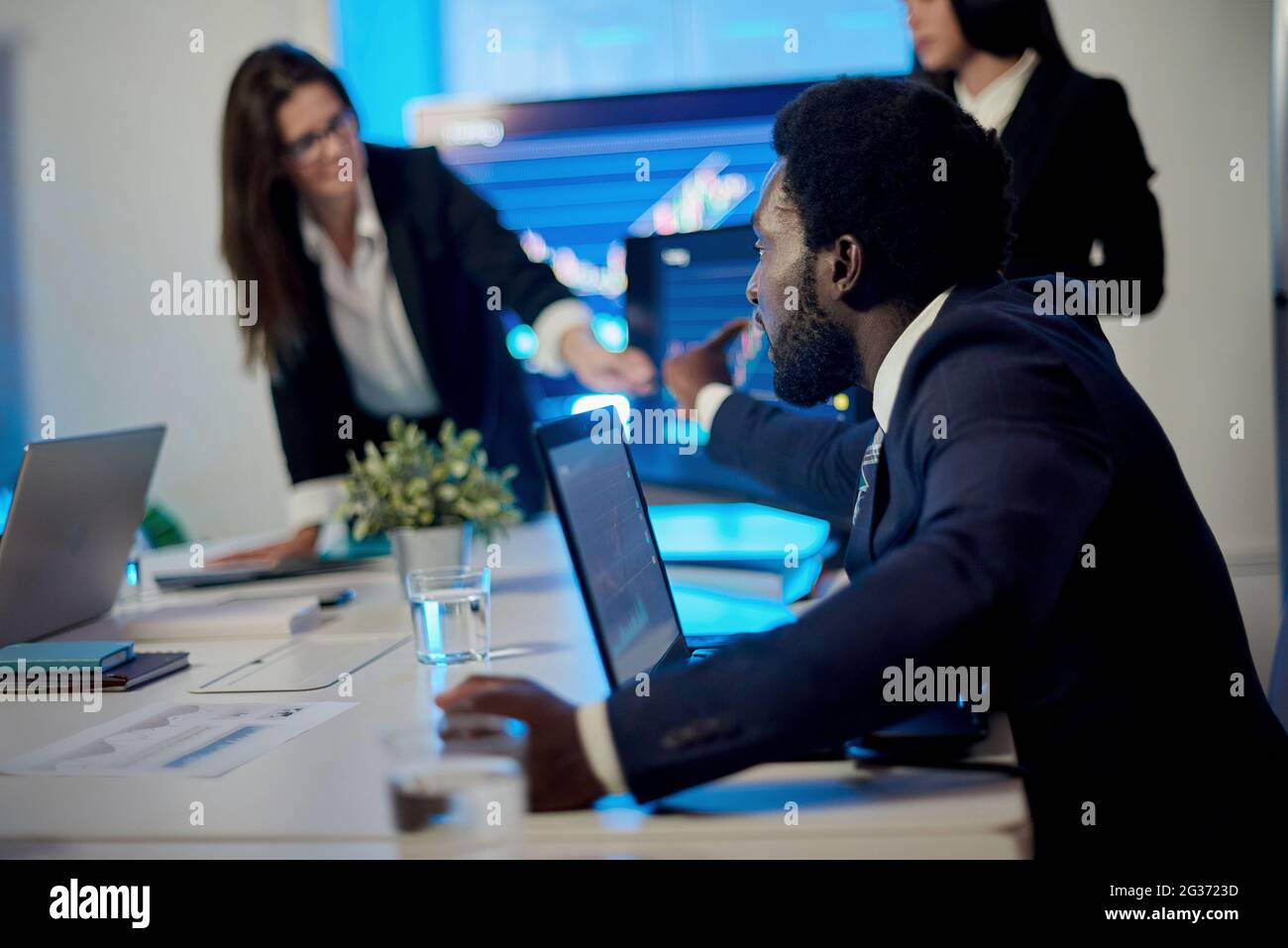 Crop multiracial employees working at table with laptops in office Stock Photo