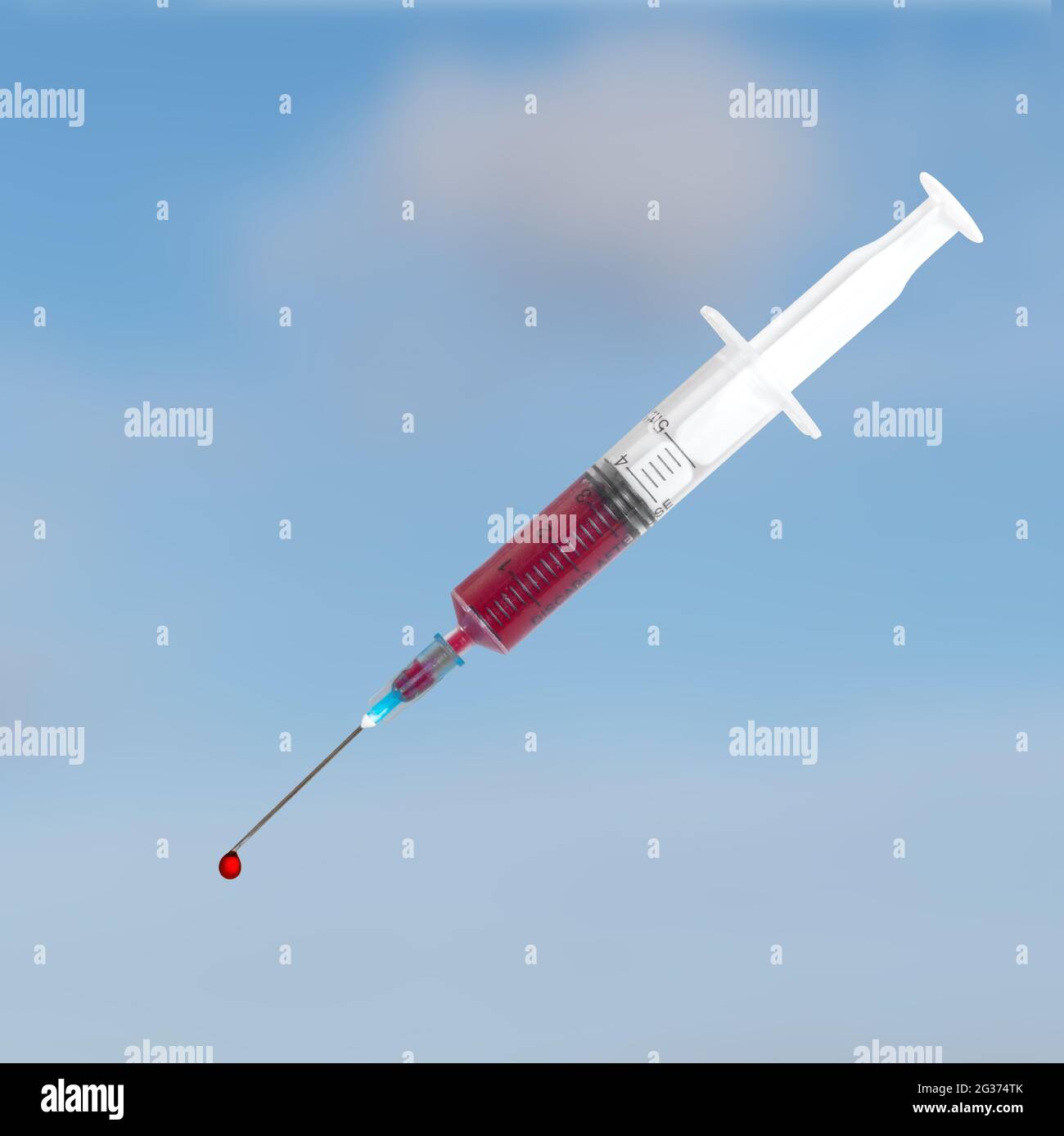 A single use syringe with blood and droplet over sky. Stock Photo