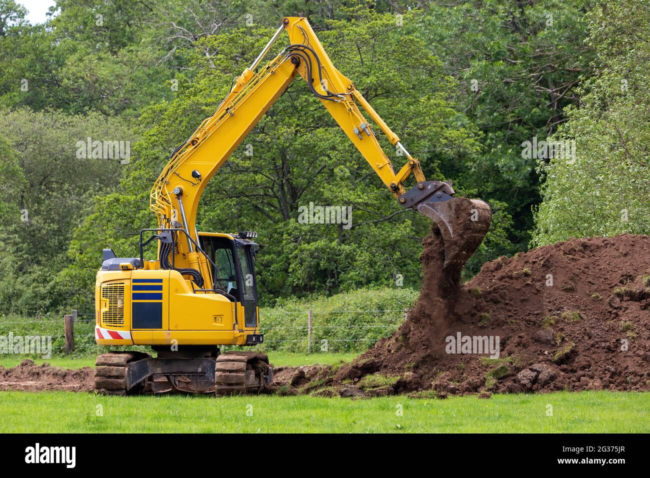 An Excavator or digger dropping dirt from its bucket Stock Photo Alamy