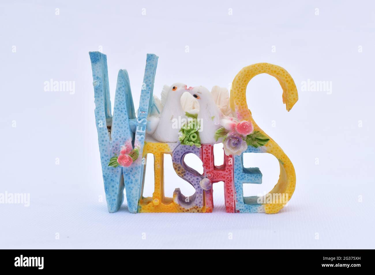 Closeup shot of Best Wishes with doves figurine isolated on white background Stock Photo
