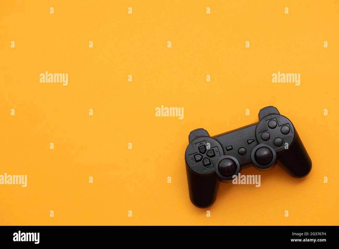 Black video game controller on a bright yellow background Stock Photo ...