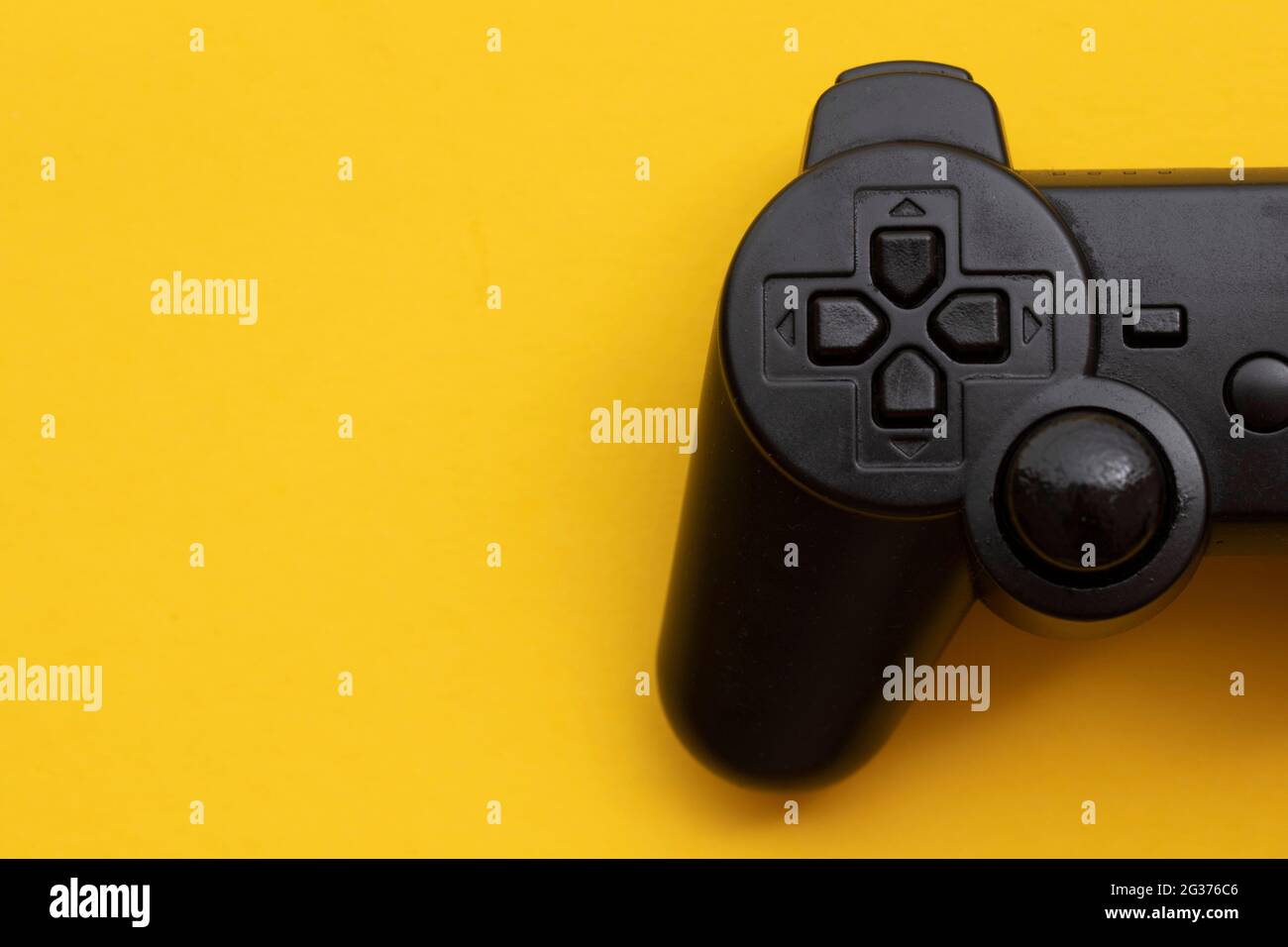 Black video game controller on a bright yellow background Stock Photo ...