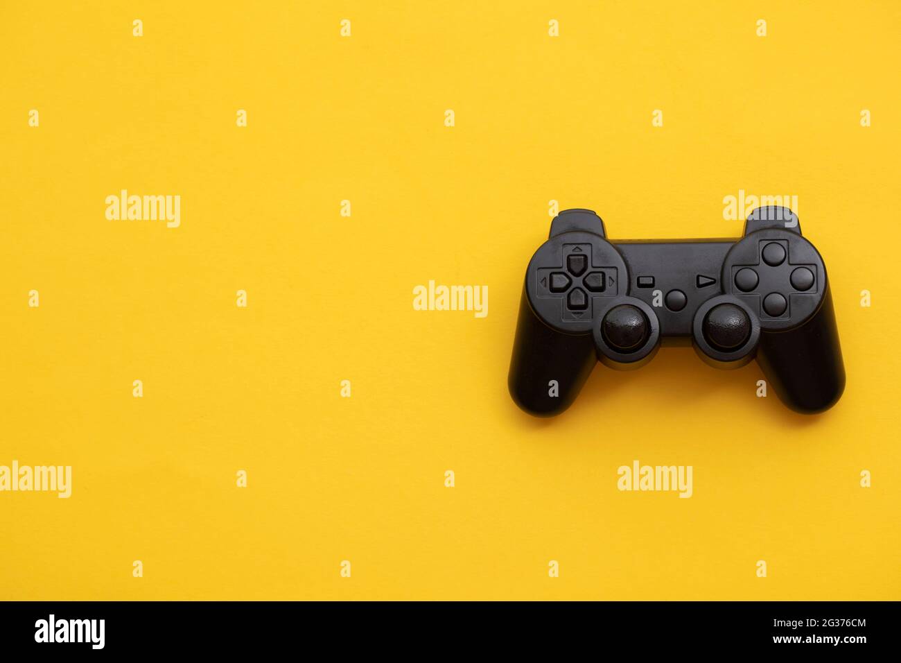 Black video game controller on a bright yellow background Stock Photo ...