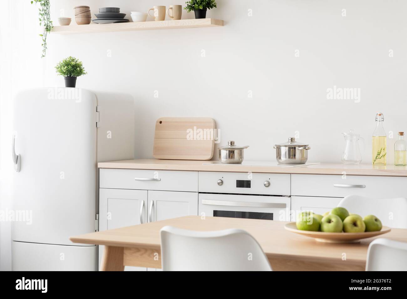 Cozy kitchen design with utensils. White furniture, stove with kettles
