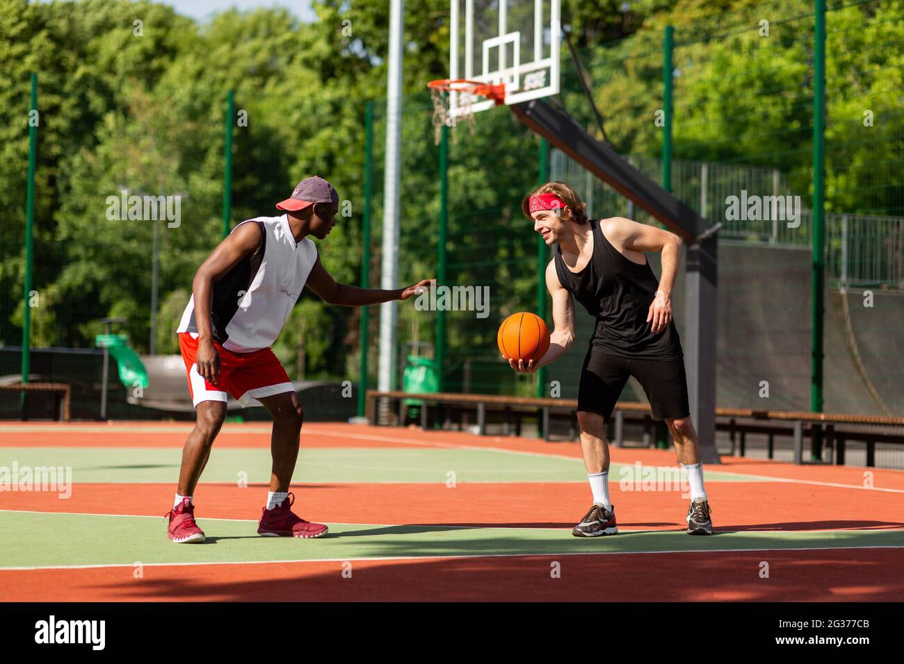 Professional basketball players having friendly match at outdoor arena Stock Photo