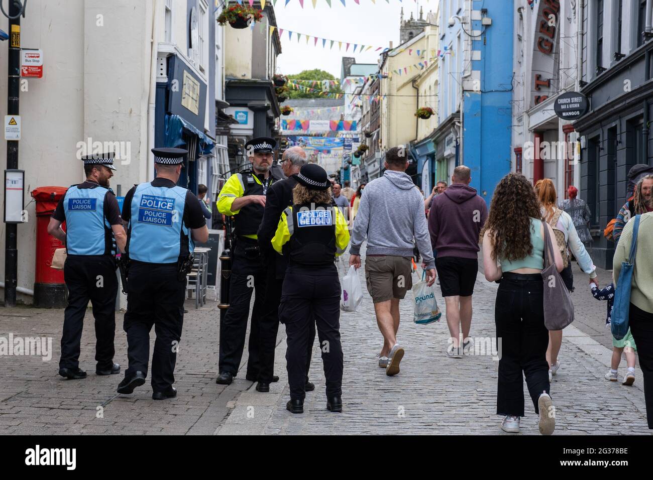 Police forces from over the UK including Heddlu working the Falmouth main streets during the G7 summit in Falmouth. Friendly group chat with public Stock Photo