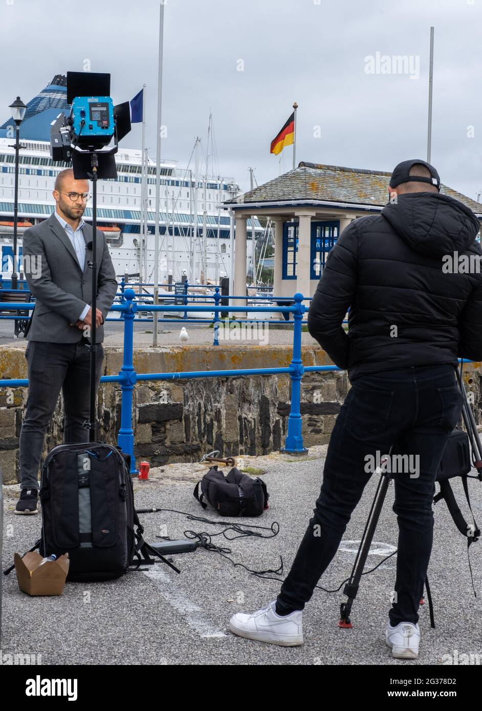 News reporters talking to camera and interviewing with their cameraman as they cover the protests and stories from the G7 Summit in Falmouth Stock Photo
