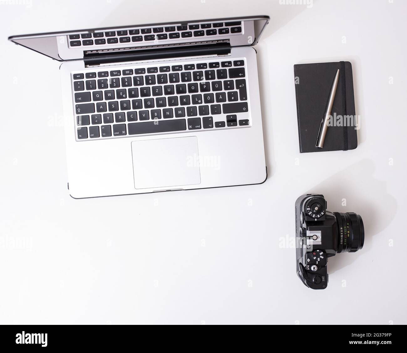 Top view of a laptop, a camera and a notebook isolated on a white ...