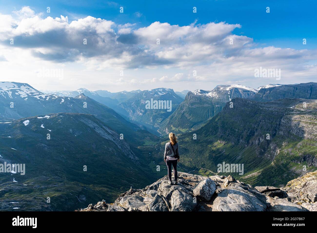 Woman standing on Dalsnibba View point, Geirangerfjord, Sunmore, Norway Stock Photo