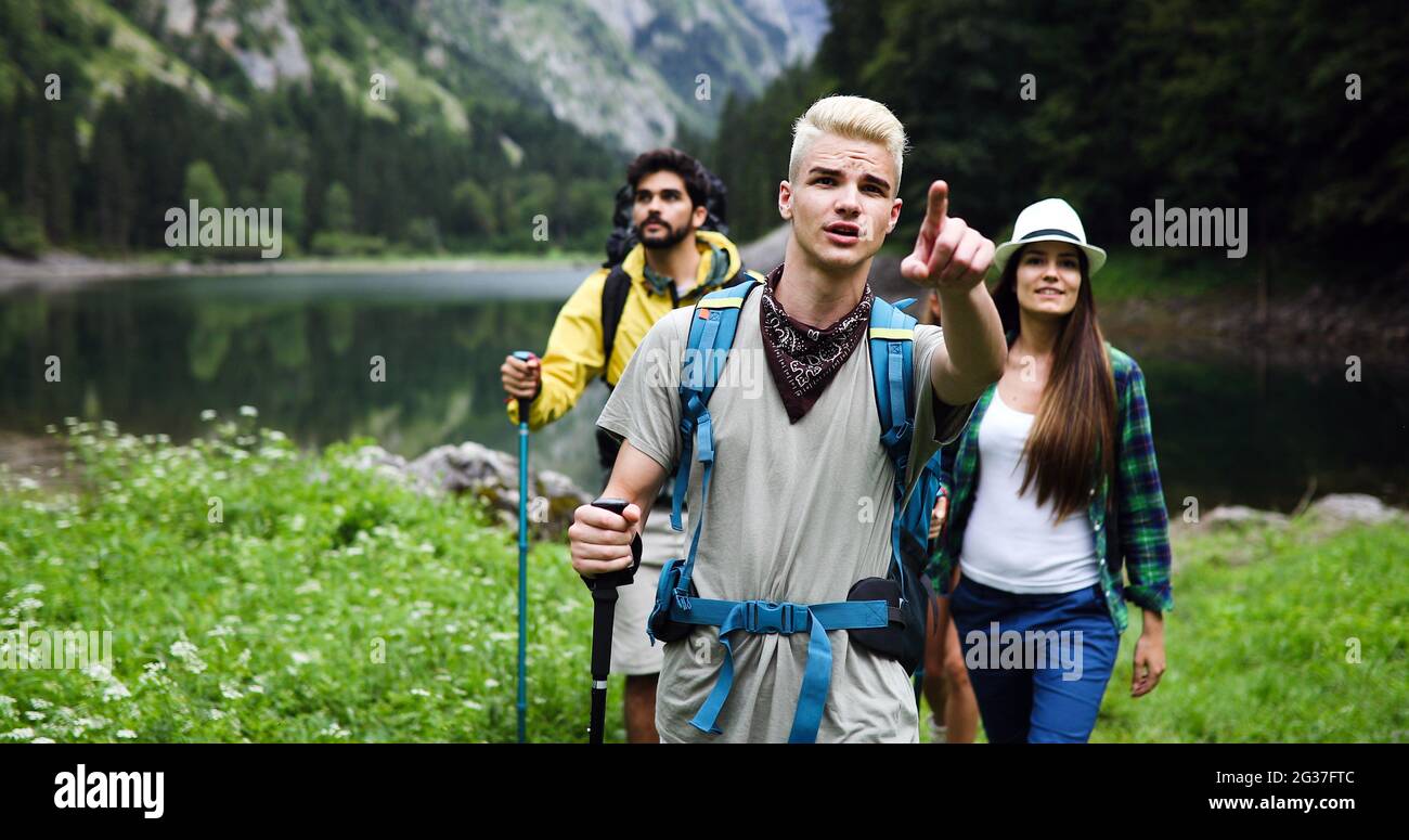 Group of happy friends with backpacks hiking together Stock Photo - Alamy