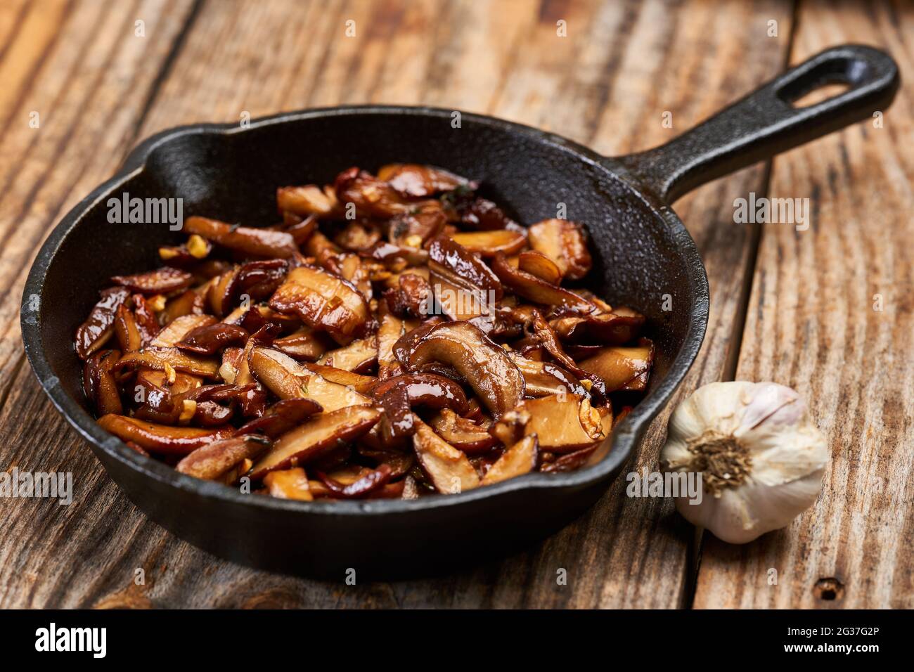 Sauteed cep (bolete) wild mushrooms with garlic and herbs in the frying pan Stock Photo