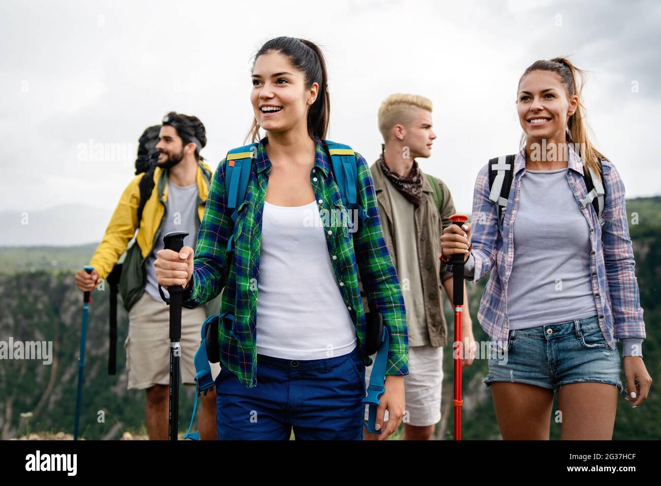 Group of young friends hiking in countryside. Multiracial happy people ...