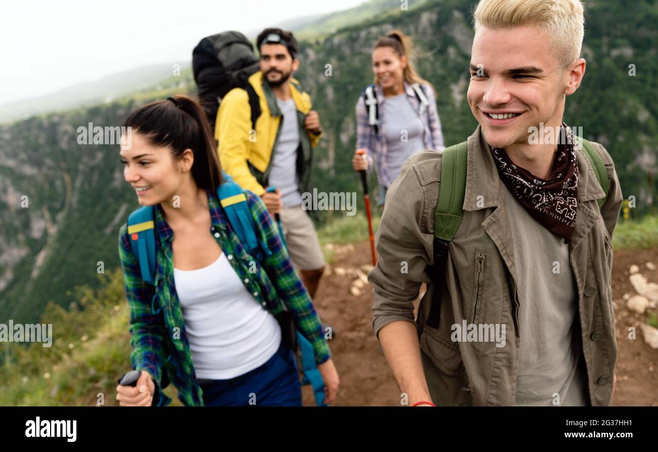 Group of young friends hiking in countryside. Multiracial happy people ...