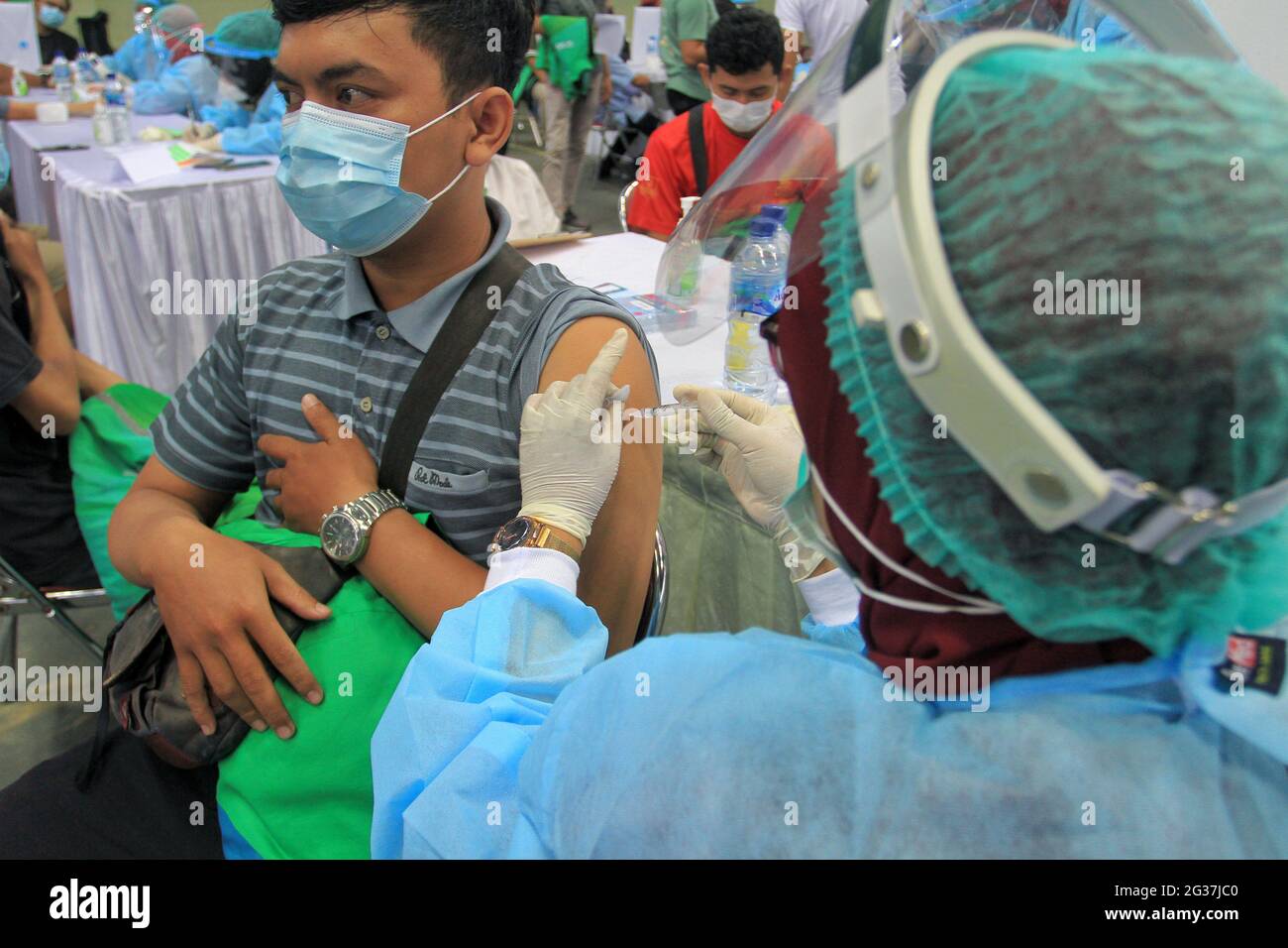 Jakarta, Indonesia. 14th June, 2021. A man receives a dose of COVID-19 vaccine during a mass vaccination in Yogyakarta, Indonesia, June 14, 2021. Due to the surging increase of COVID-19 cases since the past several days in the country, Indonesia resorted to boosting the vaccination program against the lingering coronavirus disease. Credit: Joni/Xinhua/Alamy Live News Stock Photo