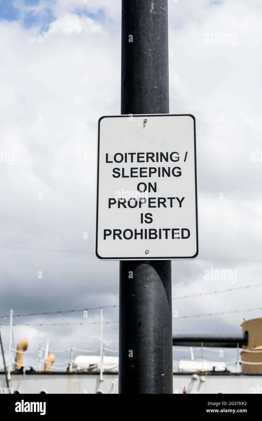 Sign that says not to loiter or sleep on the premises. Stock Photo