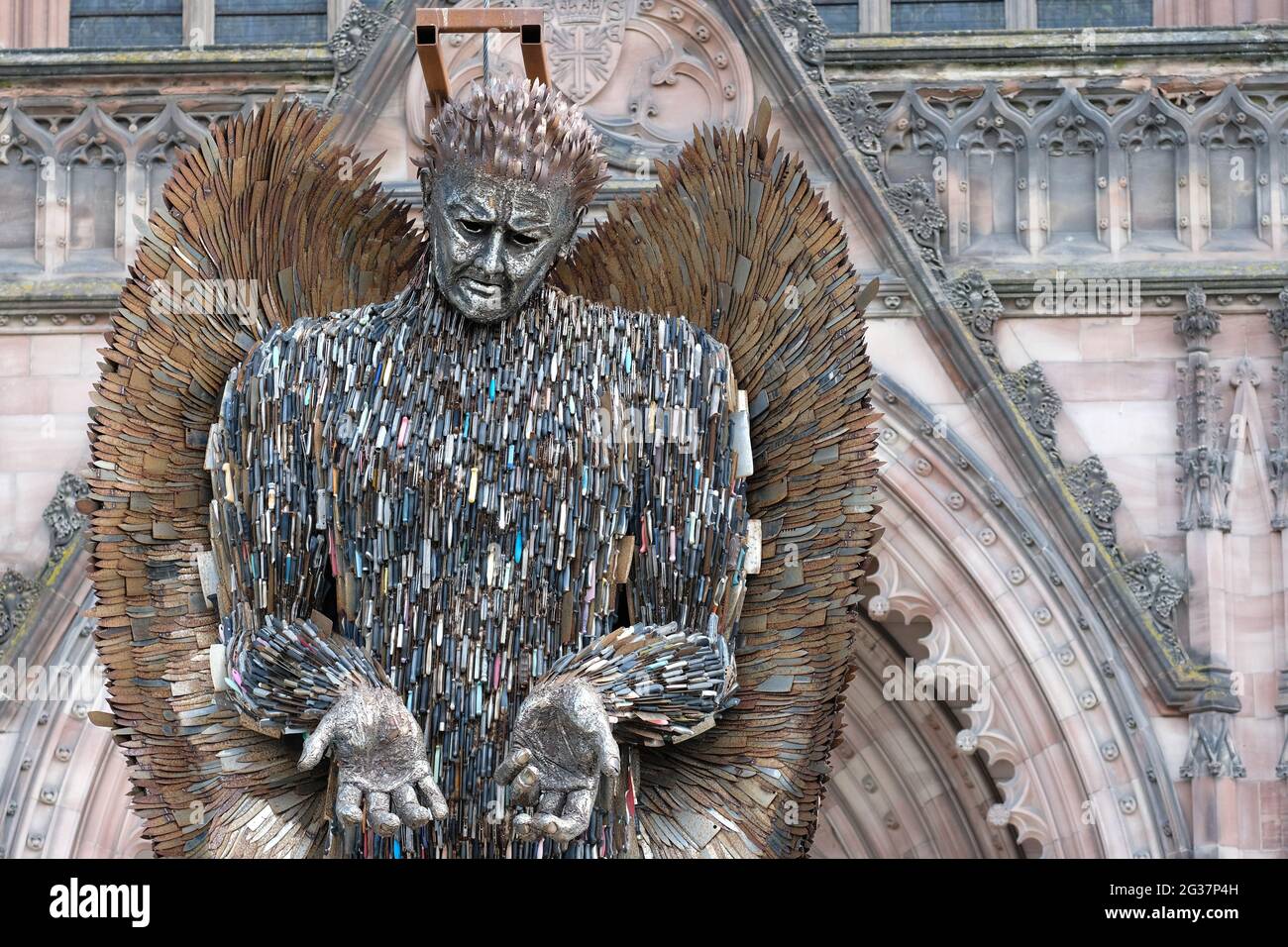 Hereford, Herefordshire, UK - Monday 14th June 2021 - The Knife Angel statue aloft outside the Cathedral supported by a frame - the 27ft tall 3.5 ton statue is made out of 100,000 confiscated knives and was created by sculptor Alfie Bradley. The Knife Angel statue raises awareness of the impact of knife crime and will be displayed outside Hereford Cathedral until 12th July 2021. Photo Steven May / Alamy Live News Stock Photo