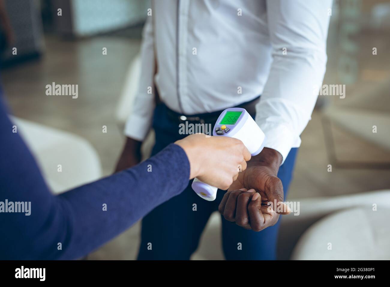 Two diverse business colleagues taking temperature Stock Photo