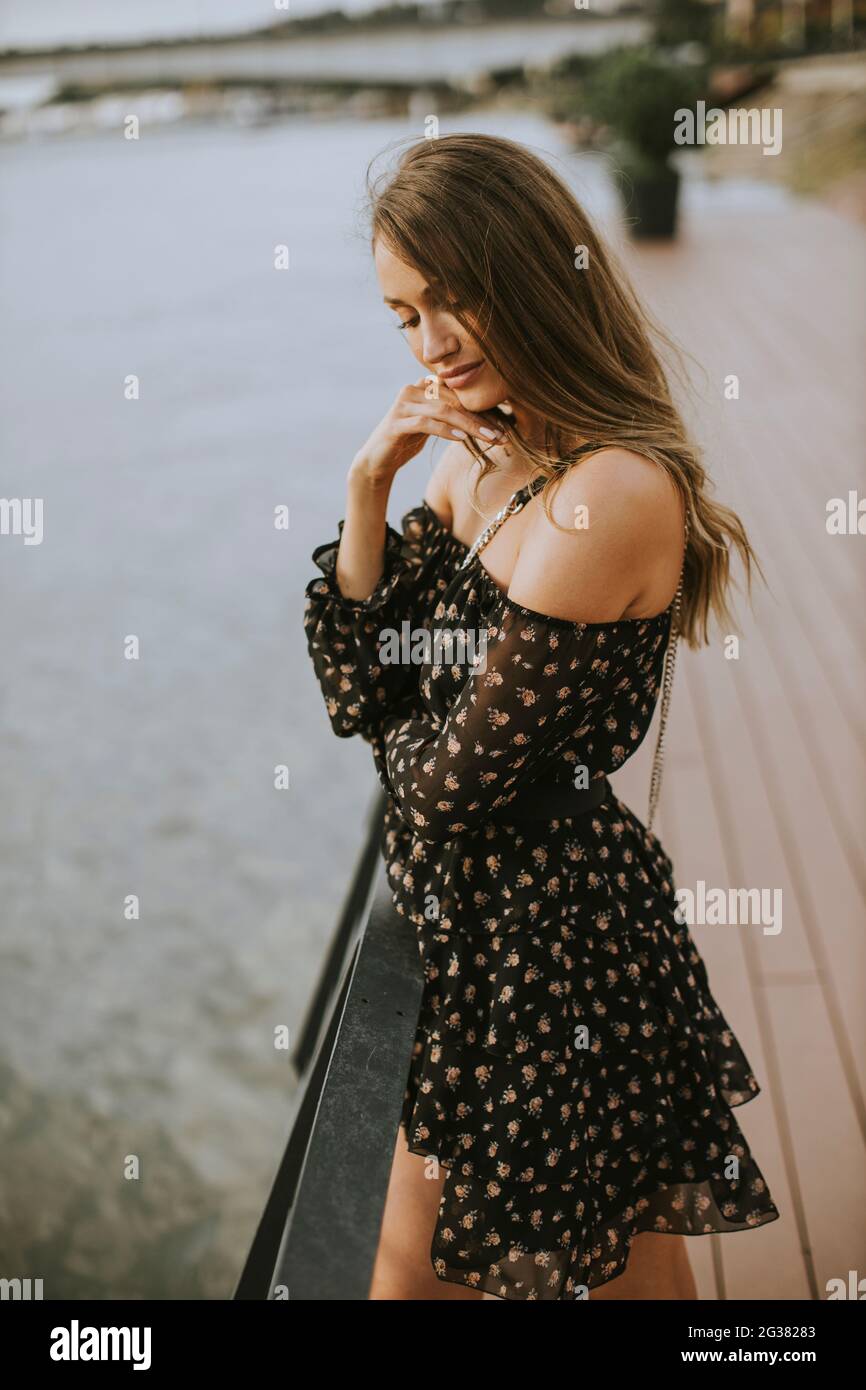 Pretty young long hair brunette woman standing on the riverside Stock ...