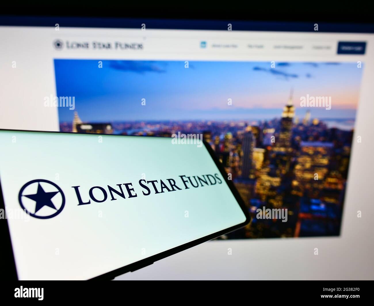 Cellphone with logo of US investment company Lone Star Funds on screen in front of business website. Focus on center-right of phone display. Stock Photo
