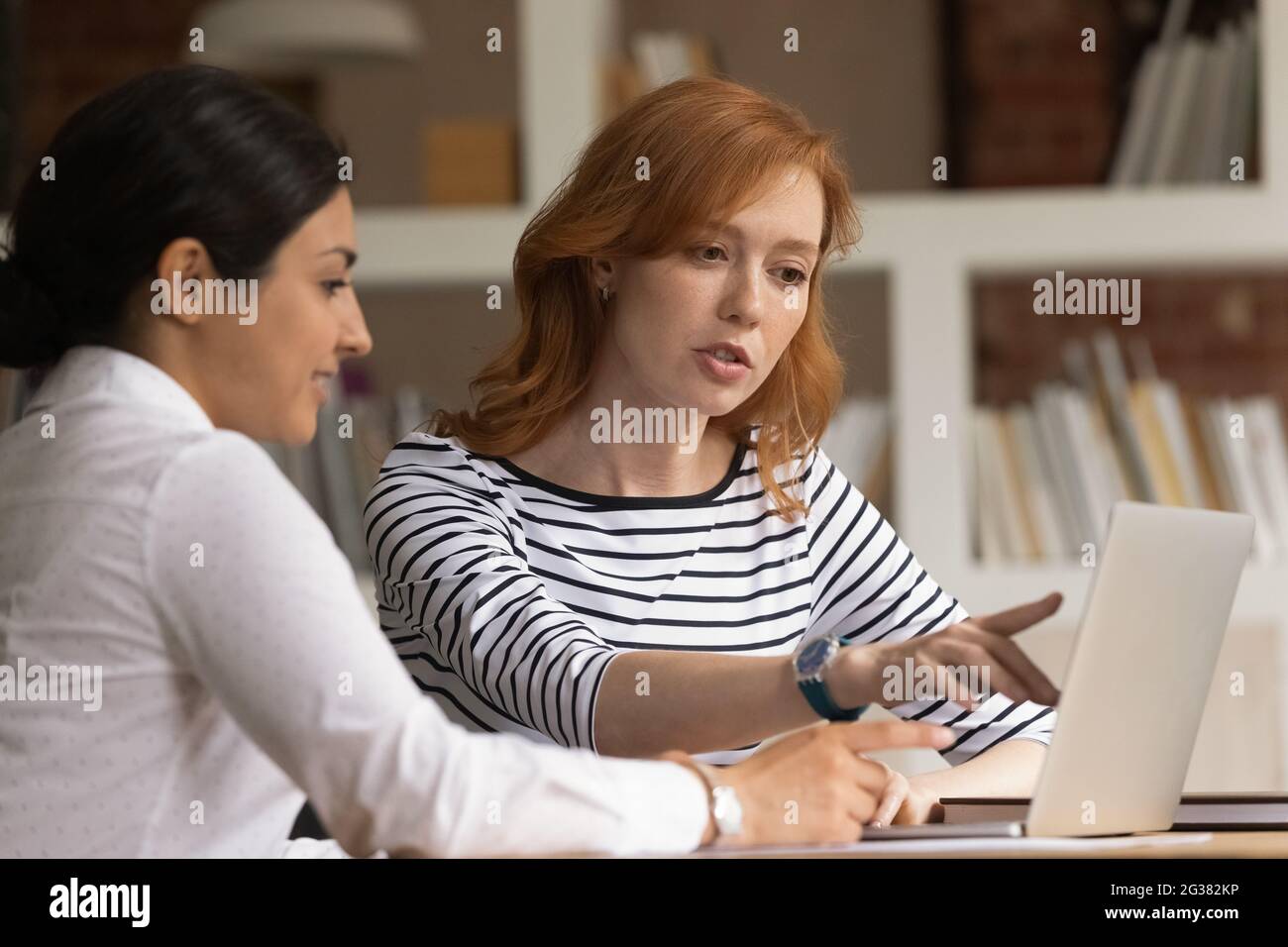 Focused young mixed race employees working on computer. Stock Photo