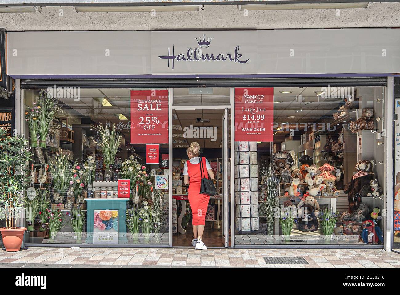 A lady in a red dress enters Hallmark Card Shop on College Street Stock