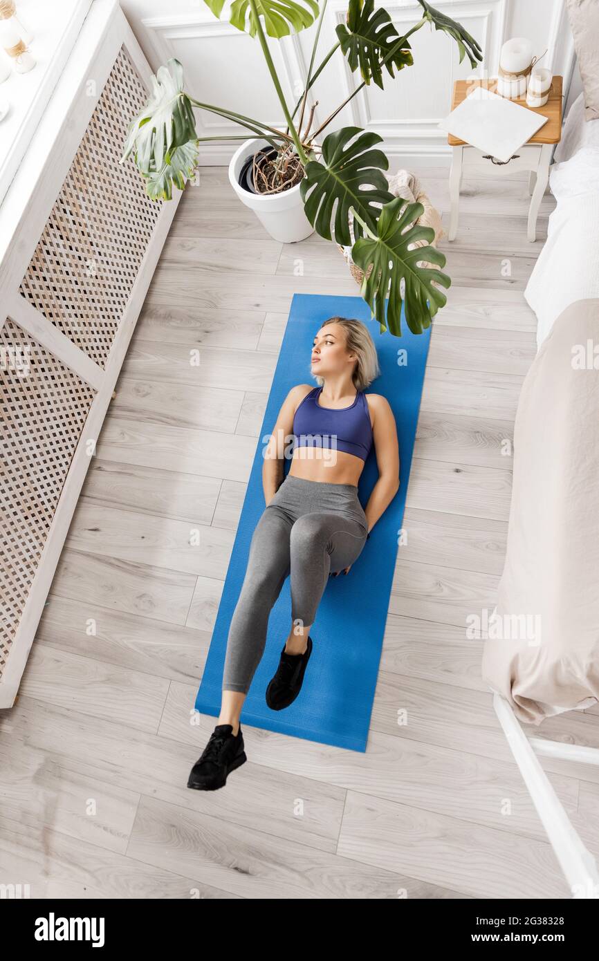 Athletic young blonde training, doing ab exercises lying down, cycling  pose, exercising, wearing sportswear, gray pants and top, full length  indoors Stock Photo - Alamy