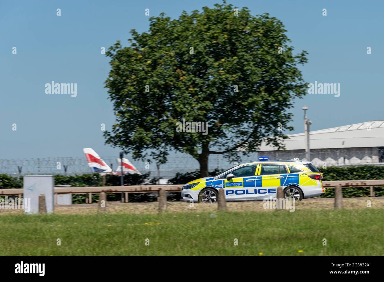 Metropolitan Police police car racing at speed with blue lights on A30 passing London Heathrow Airport, UK, on day of US President Joe Biden visit Stock Photo