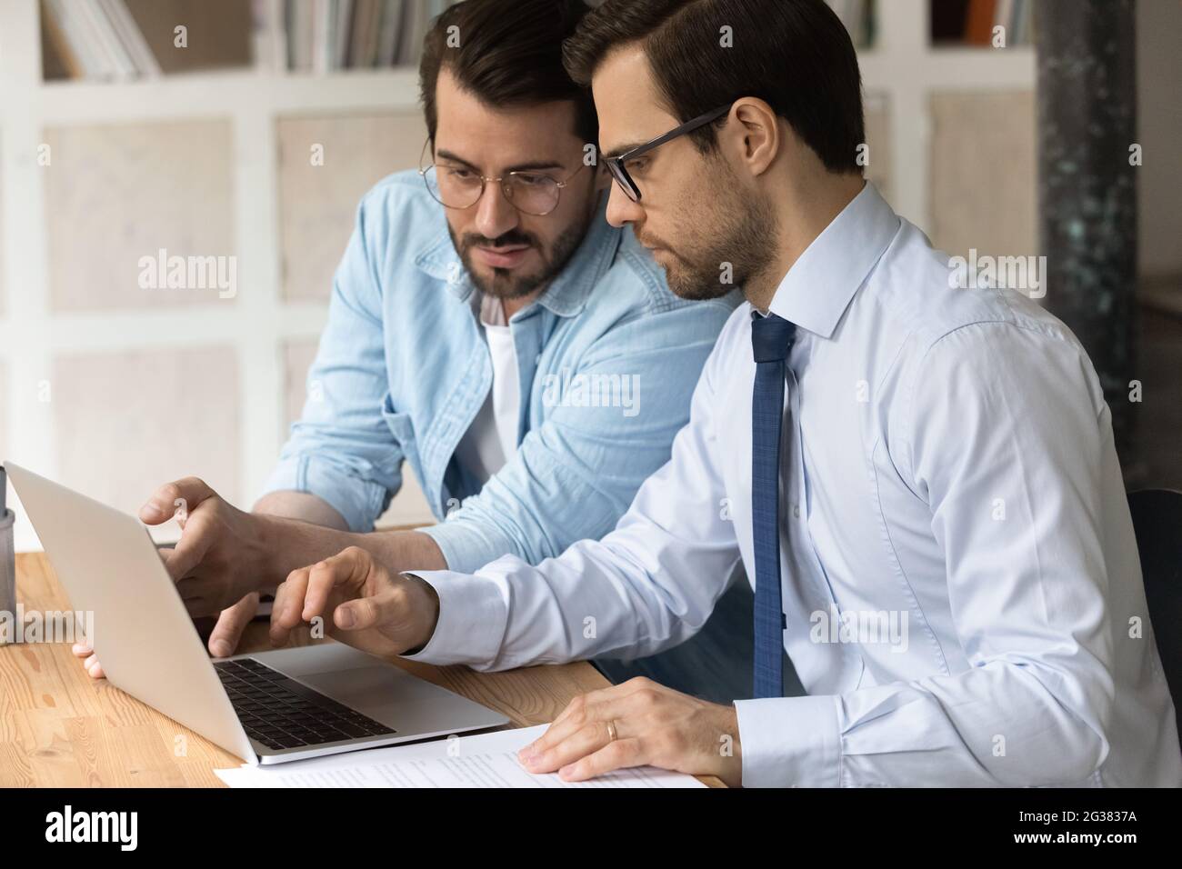 Skilled millennial employees working on computer in office. Stock Photo