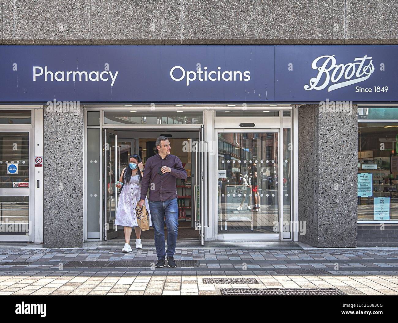 Belfast, UK. 31st May, 2021. Masked and unmasked customers leave Boots