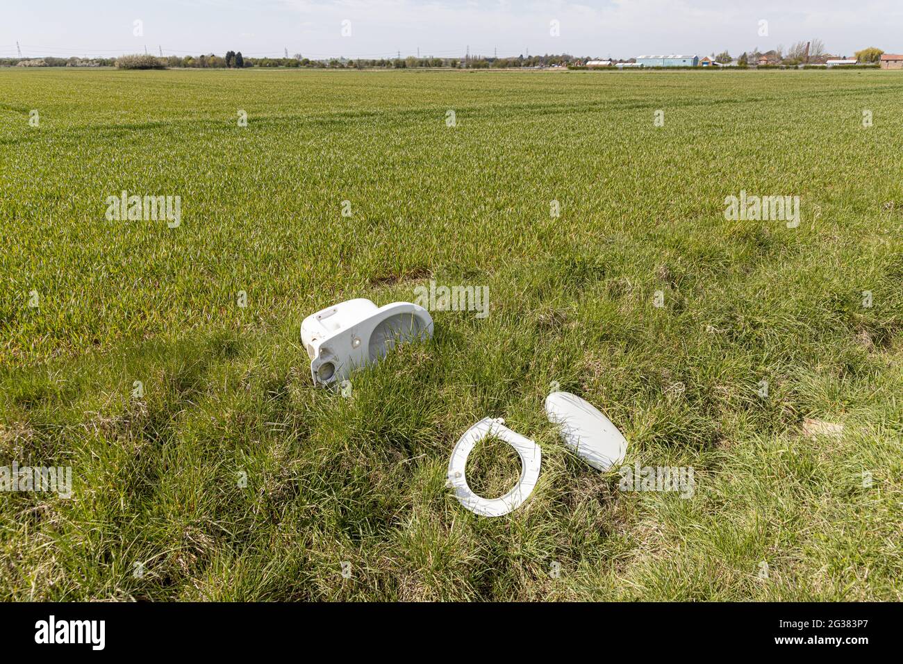 An old toilet curiously abandonded (dumped) in the middle of nowhere on the edge of a field near Owston Ferry, North Lincolnshire UK Stock Photo