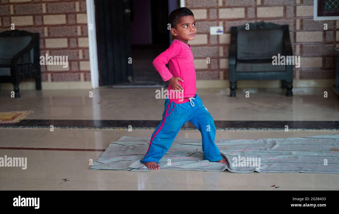 Indian cute little boy exercising at home. Family working out at home. Worldwide yoga day concept. Stock Photo