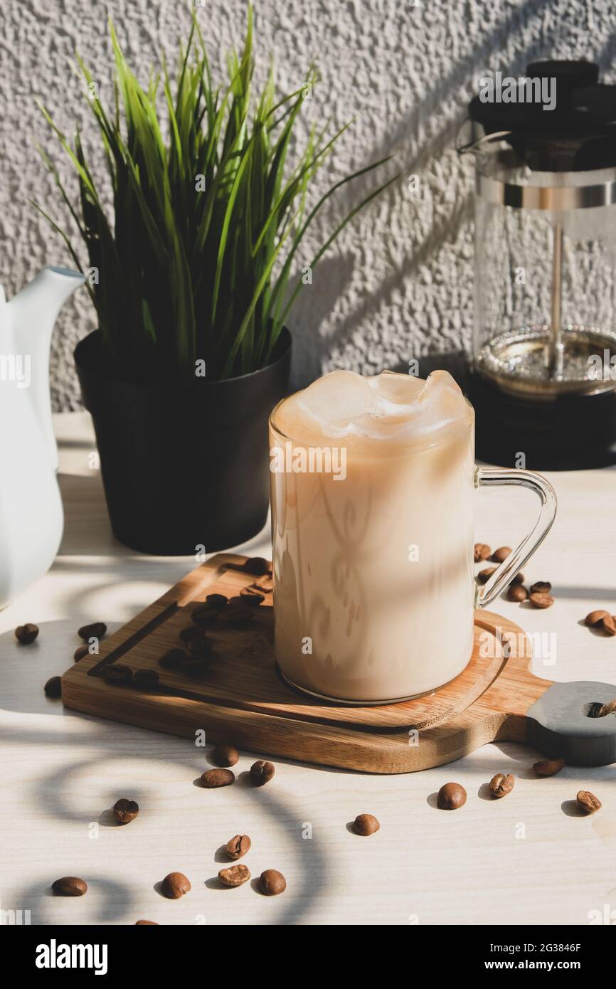 Coffee with cream with ice milk in mug with handle on table. Stock Photo