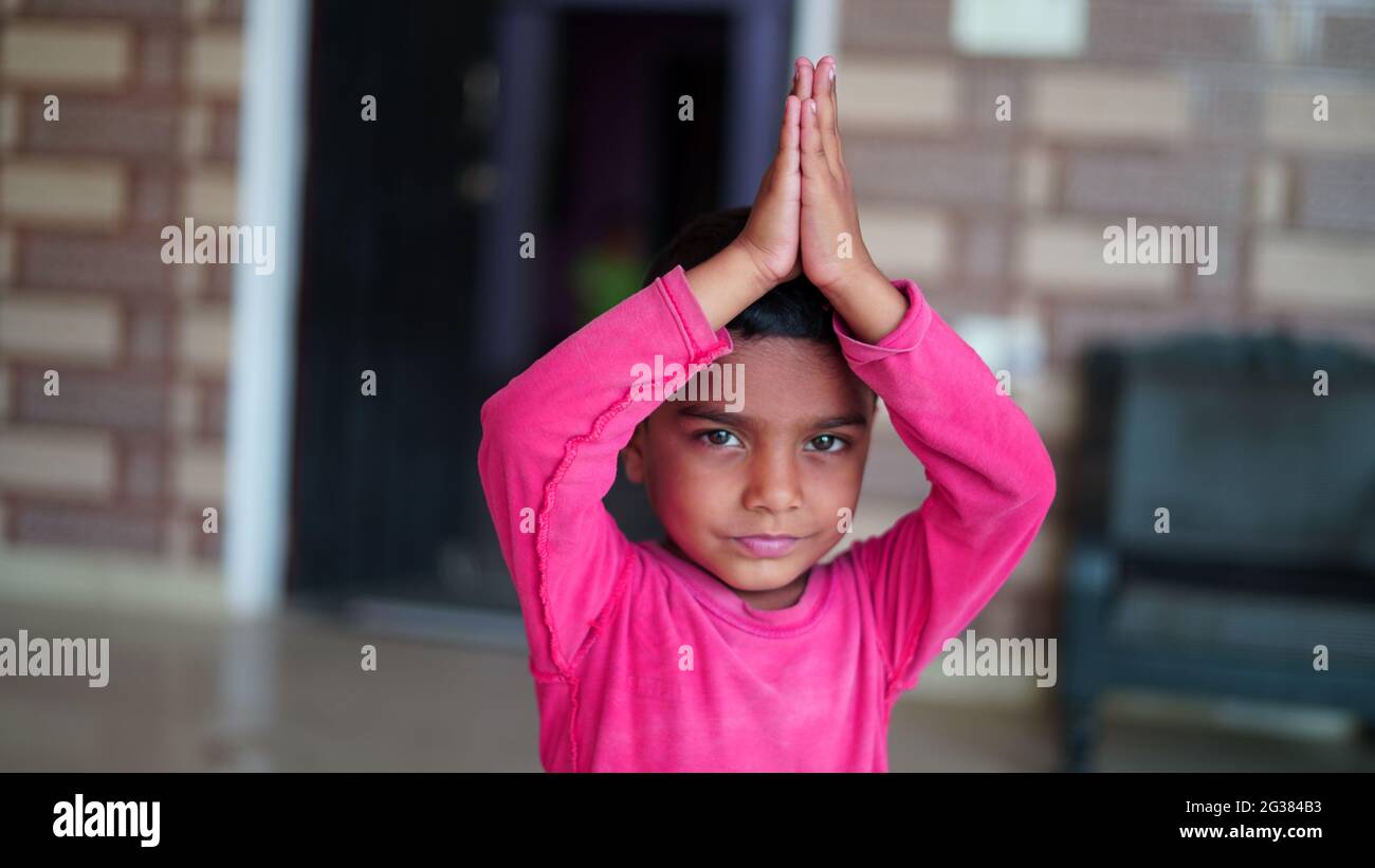 Indian cute little boy exercising at home. Family working out at home. Worldwide yoga day concept. Stock Photo