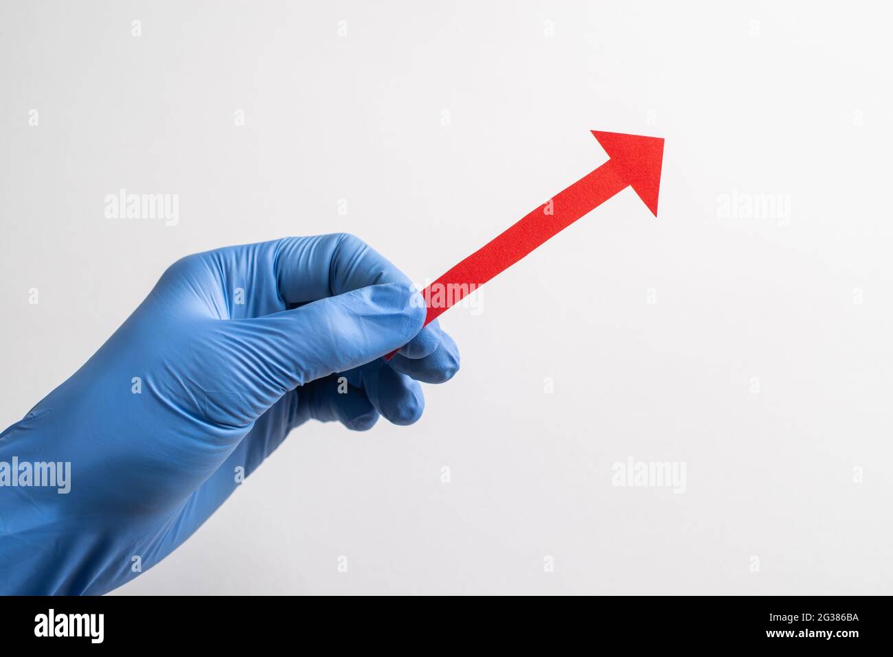 Hand in glove holding a red paper arrow pointing up to the right Stock ...