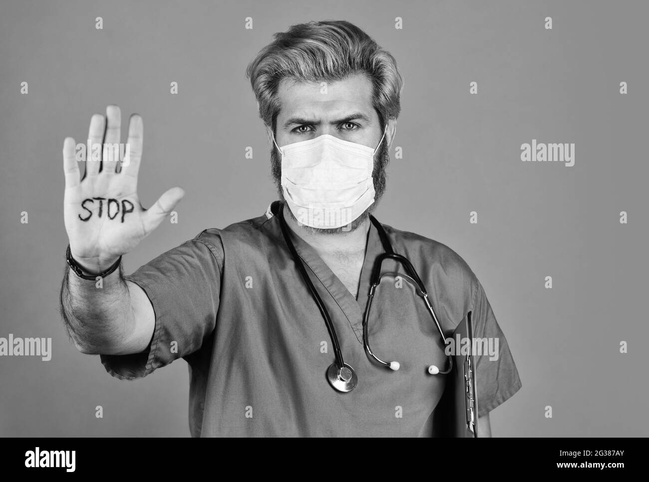 Epidemic threshold. Man in medical lab. Protective mask. Open palm stop gesture. Danger zone. Stop epidemic. Virus concept. Epidemic infection Stock Photo