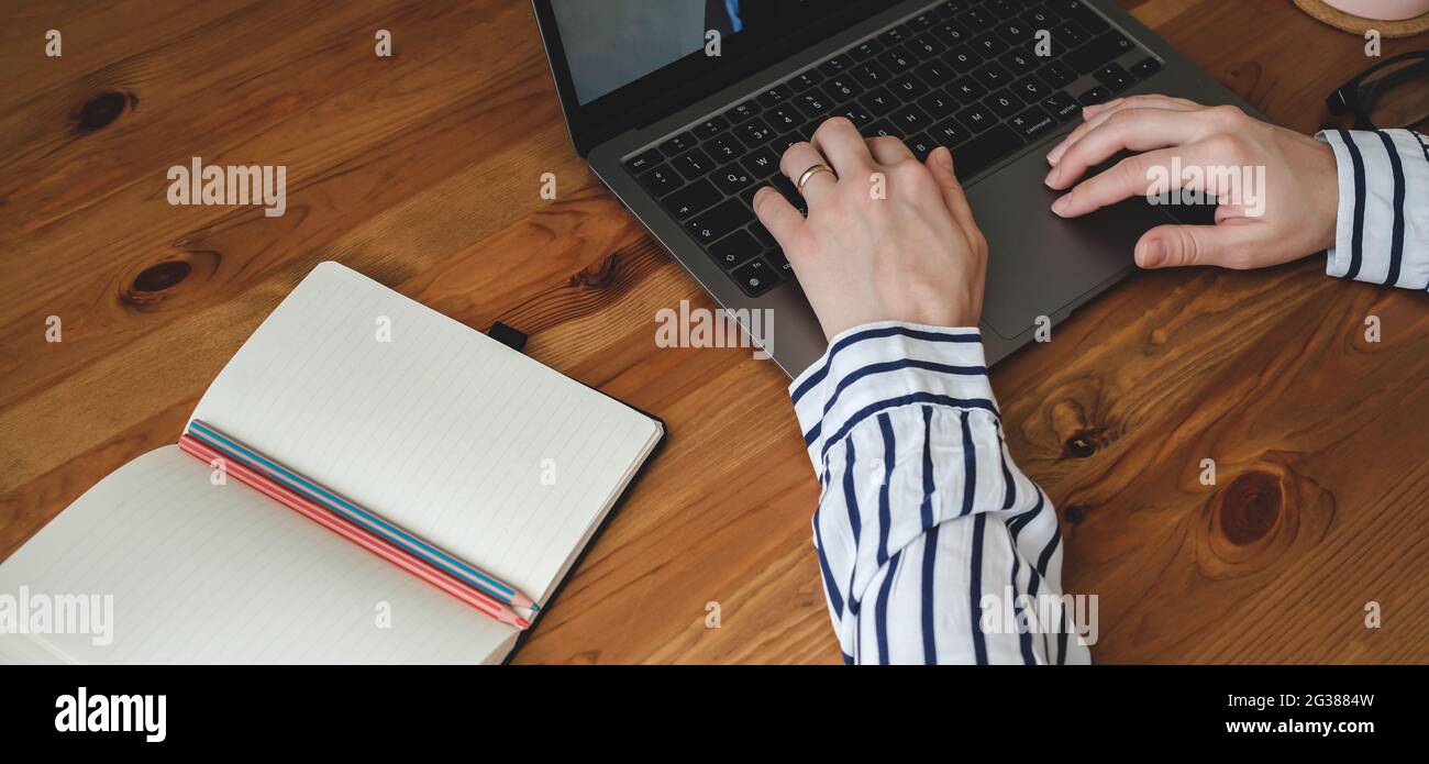 woman writing with laptop stands notepad on table Stock Photo - Alamy