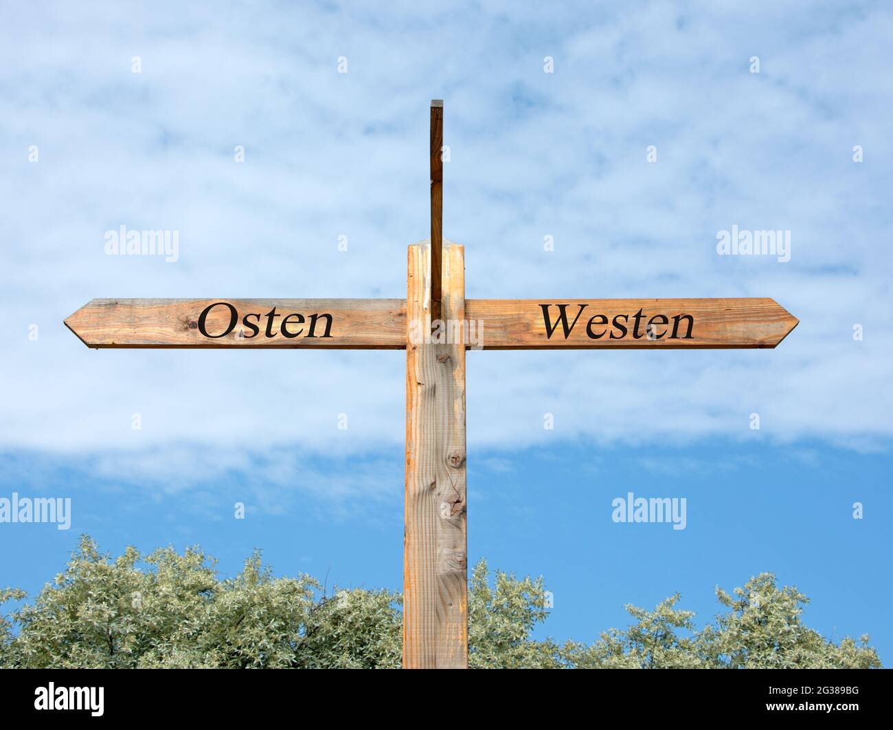 Signpost with the  inscription 'osten, westen', translation 'east, west' Stock Photo