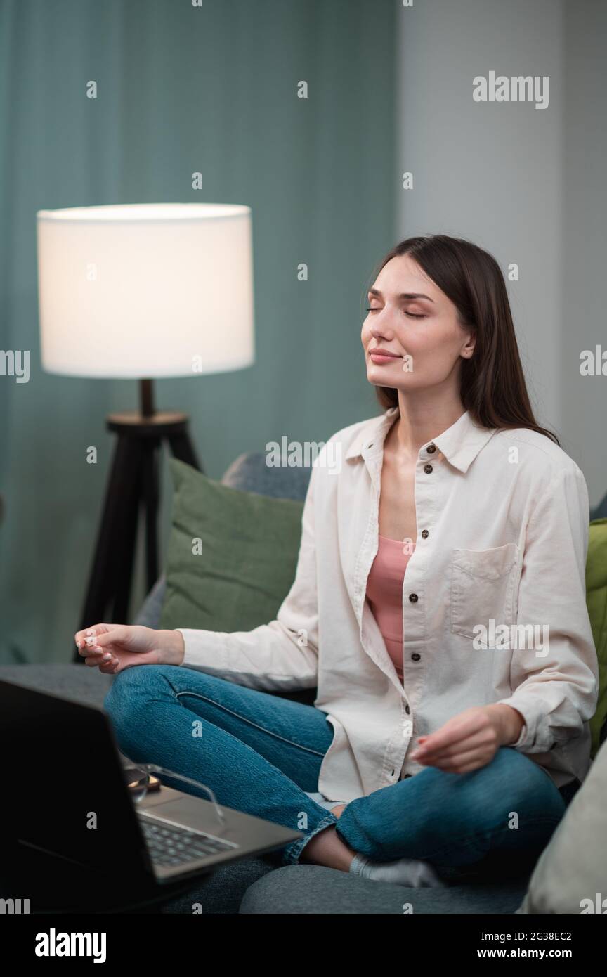 To relieve the stress of work, a pretty girl sat at home on the sofa in ...