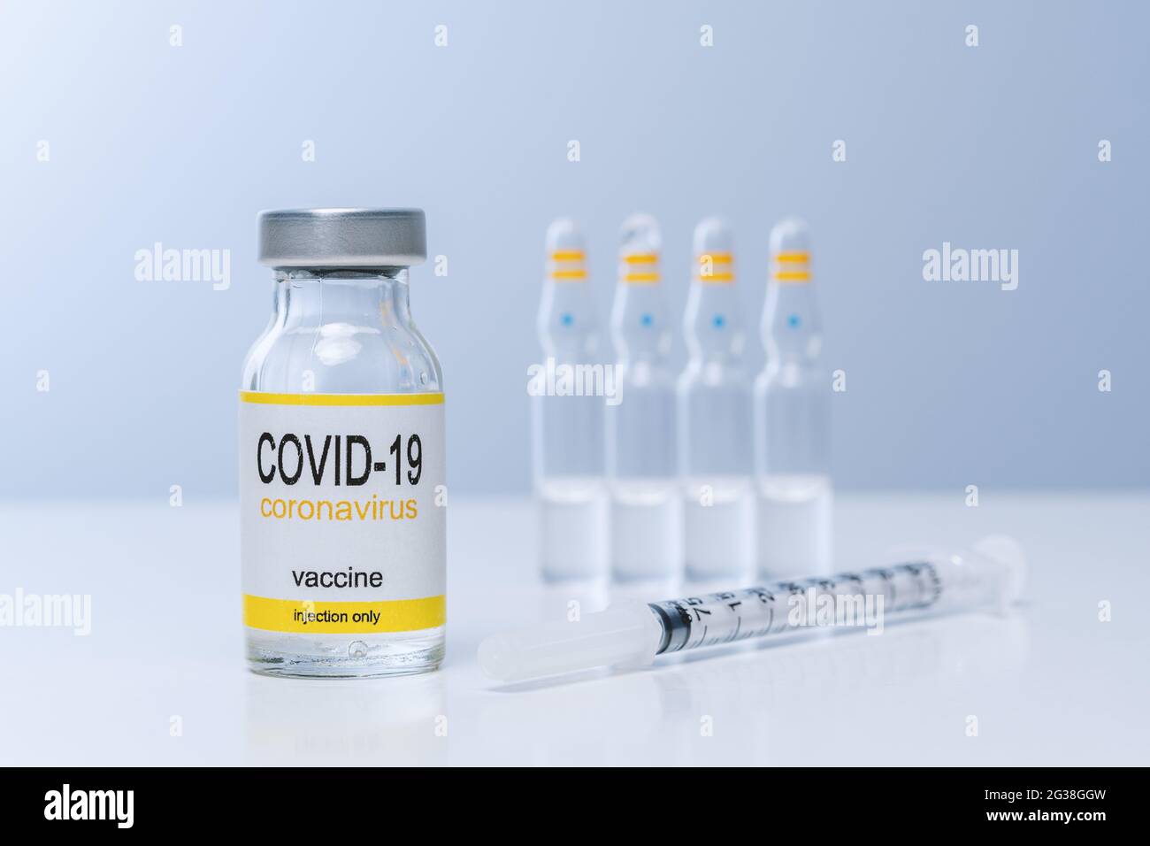 Vaccine in glass vial with syringe on a table. Vaccination ...