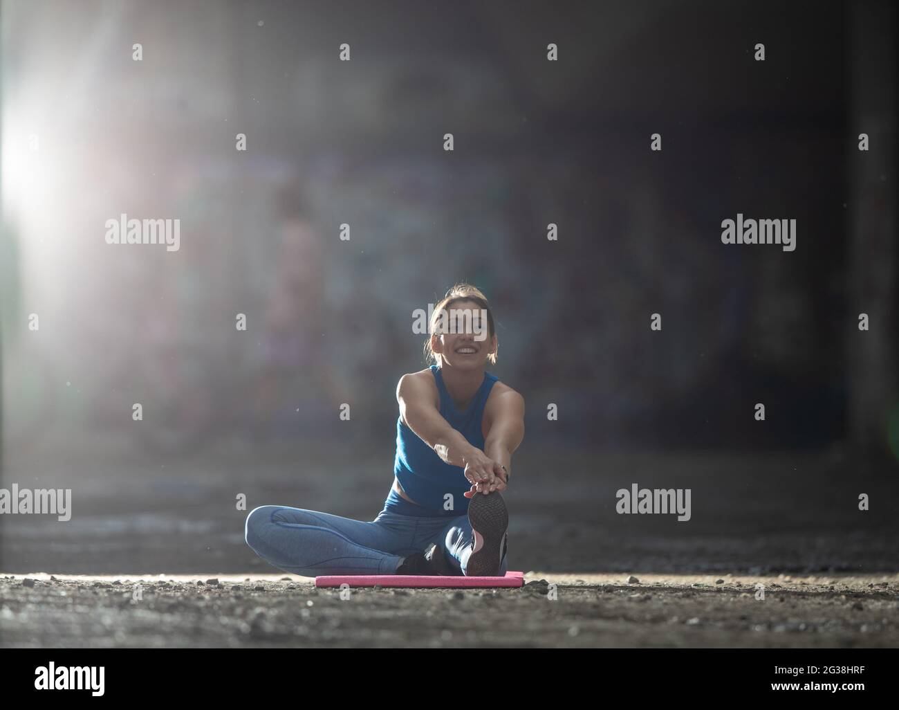 Young Female Athlete Warming Up Stretching Doing Forward Bend Sitting