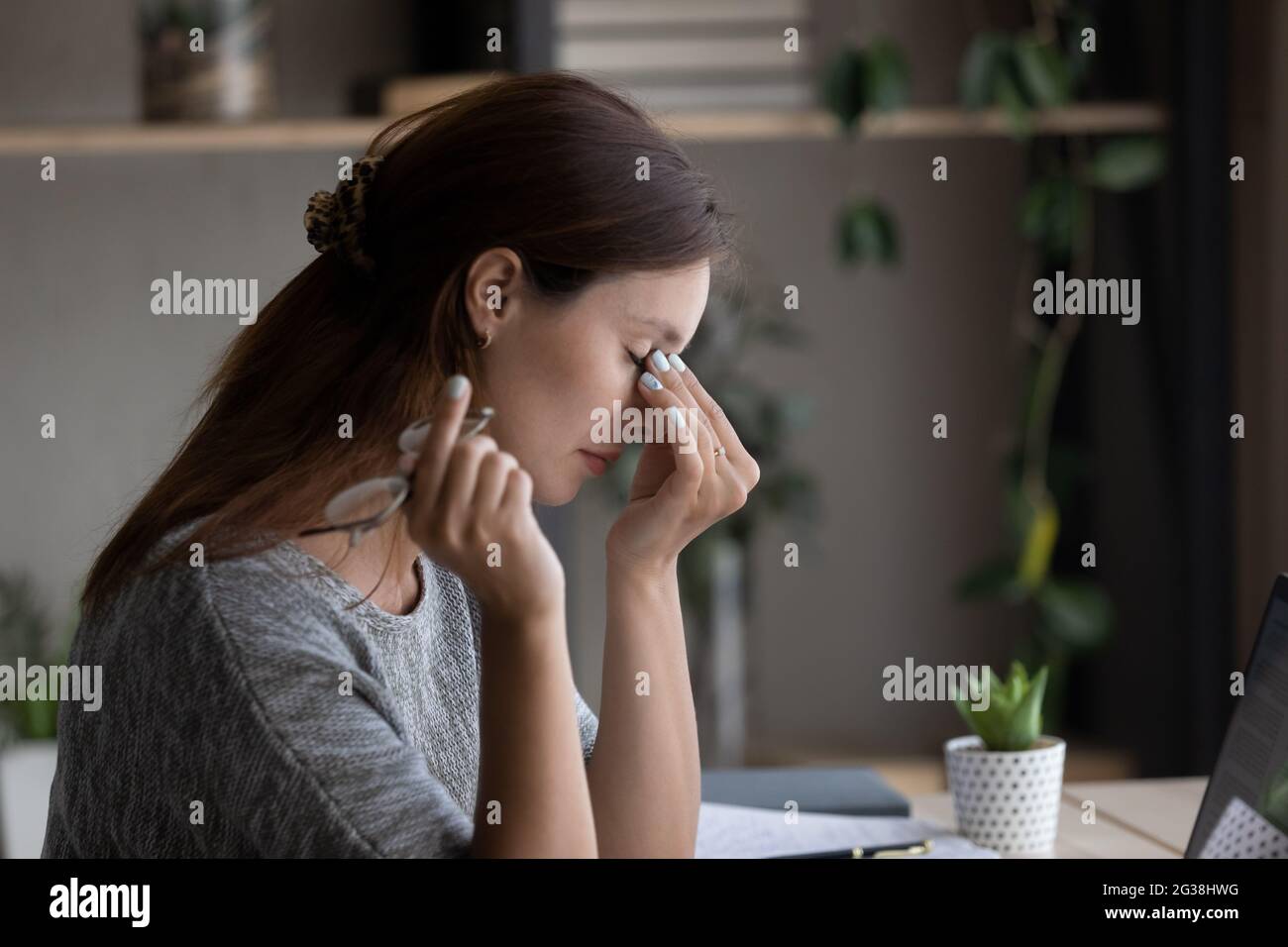 Side view tired woman taking off glasses, massaging nose bridge Stock Photo