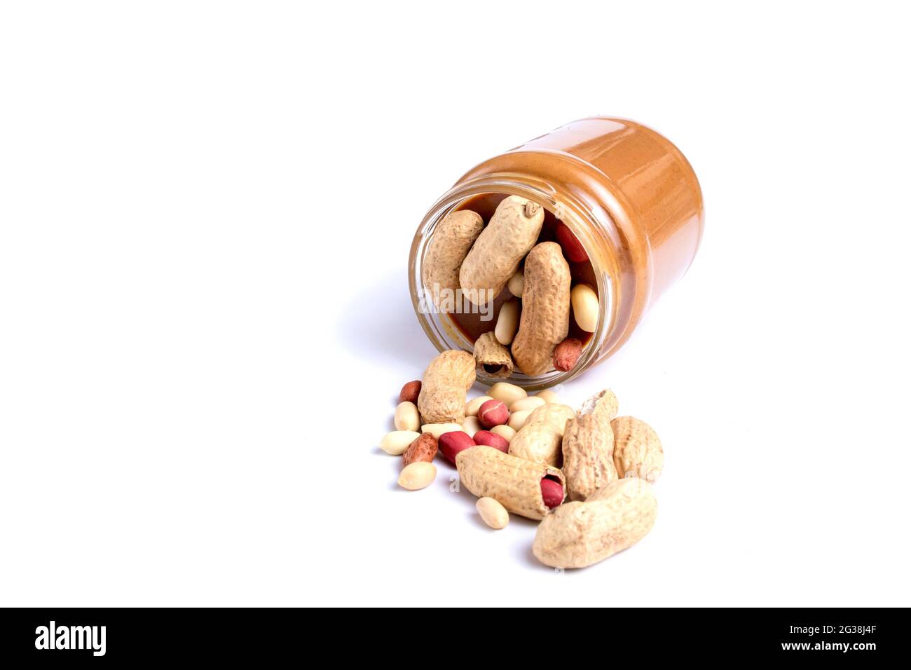 Peanut butter isolated and peanuts in the peel scattered on the white