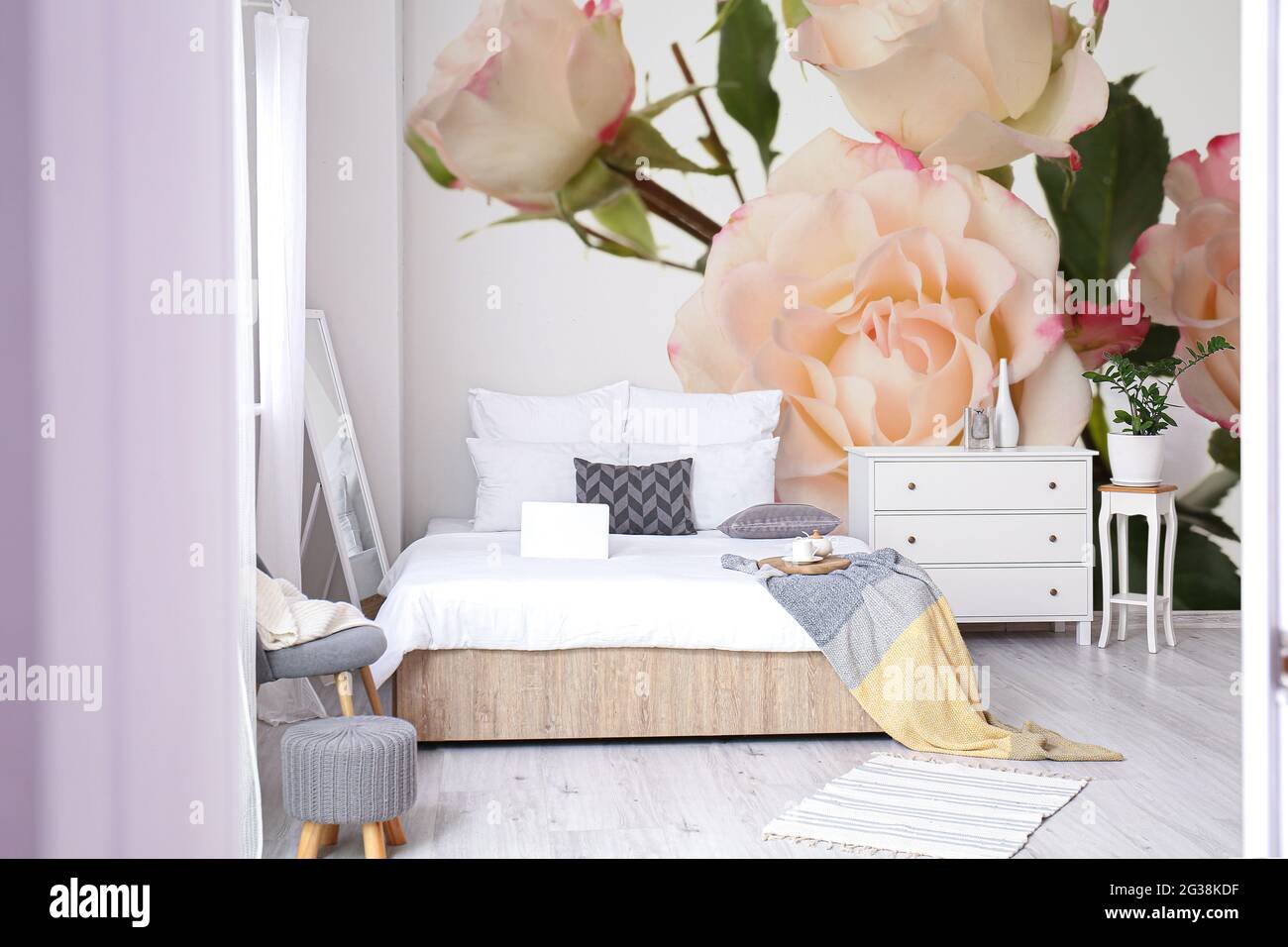 Stylish interior of bedroom with beautiful rose flowers on wall Stock ...