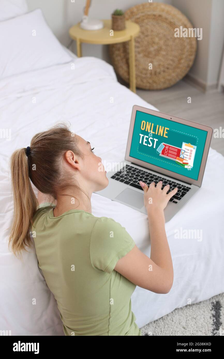 Woman with laptop passing exams online at home Stock Photo
