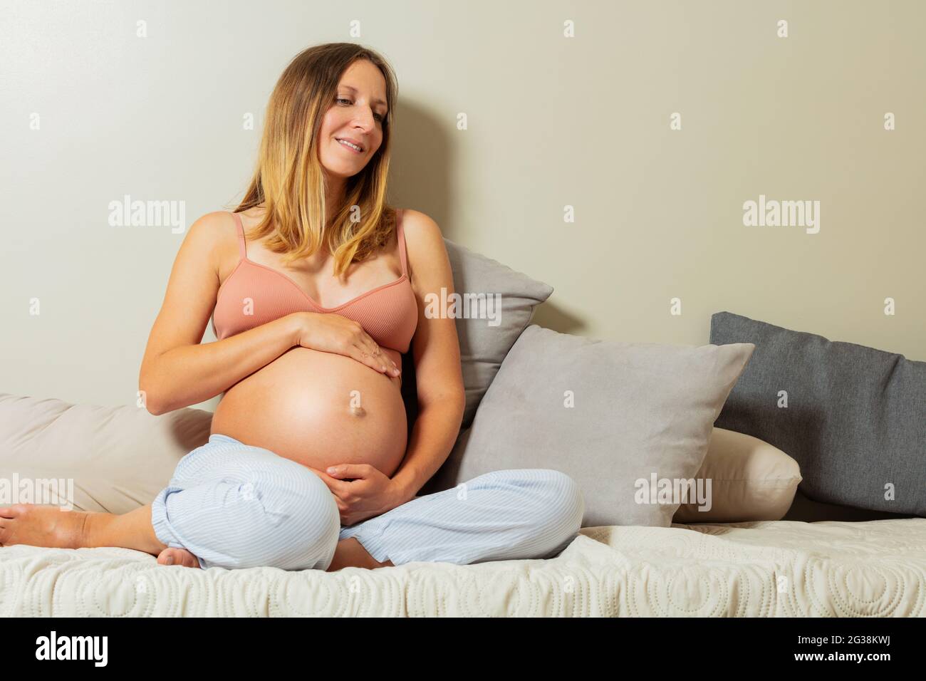 Calm positive pregnant woman touch big belly Stock Photo
